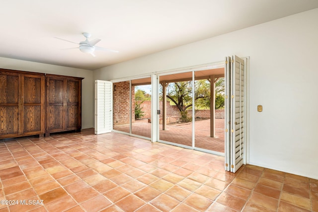 tiled empty room featuring ceiling fan