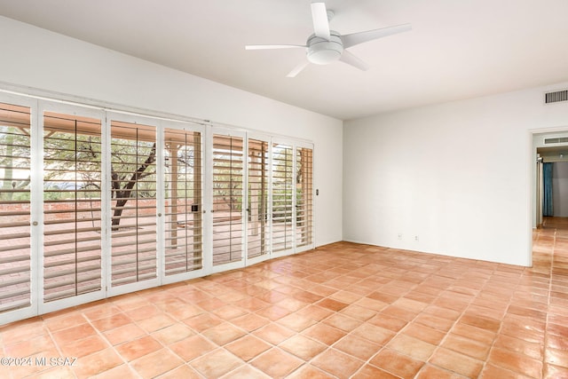 spare room with ceiling fan and light tile patterned floors