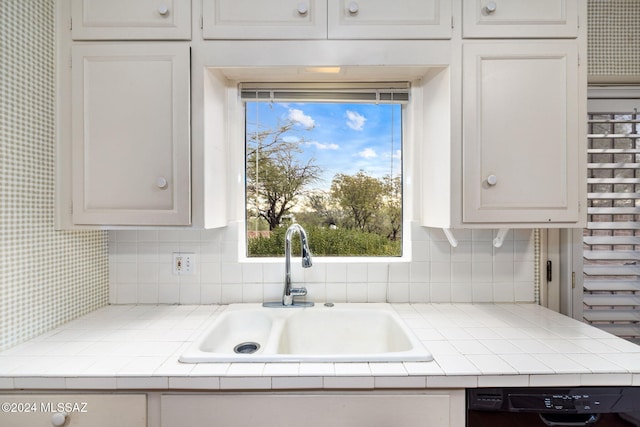 kitchen featuring white cabinetry, decorative backsplash, sink, tile counters, and dishwasher