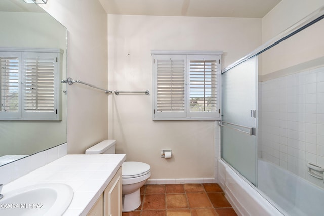 full bathroom featuring combined bath / shower with glass door, vanity, and toilet