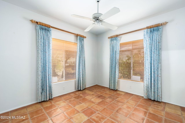 tiled spare room featuring ceiling fan