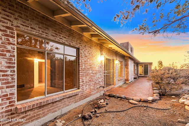 property exterior at dusk featuring a patio