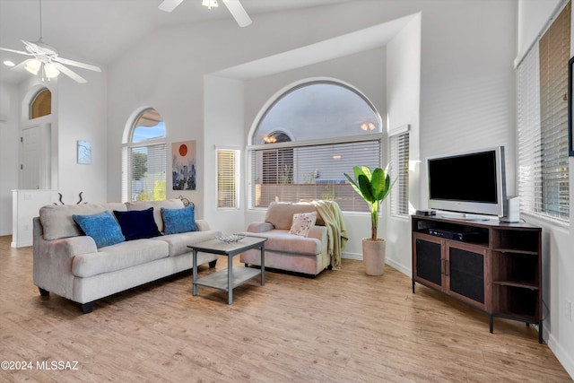 living room with ceiling fan, light wood-type flooring, and high vaulted ceiling