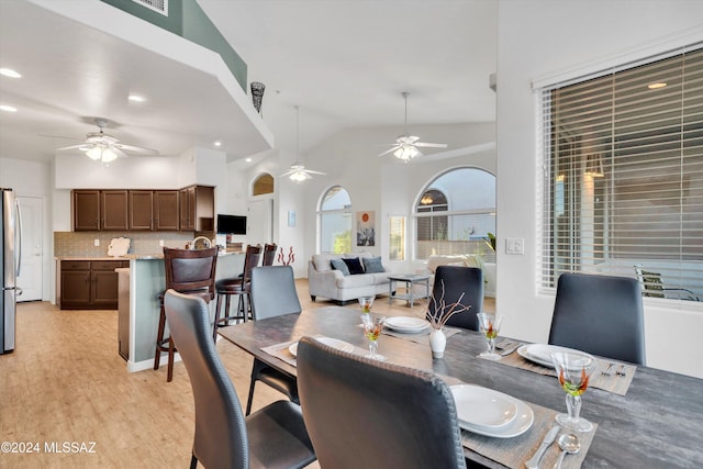 dining room featuring lofted ceiling, ceiling fan, and light hardwood / wood-style flooring