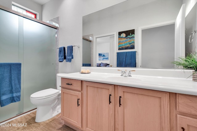 bathroom featuring a shower with door, wood-type flooring, toilet, and vanity