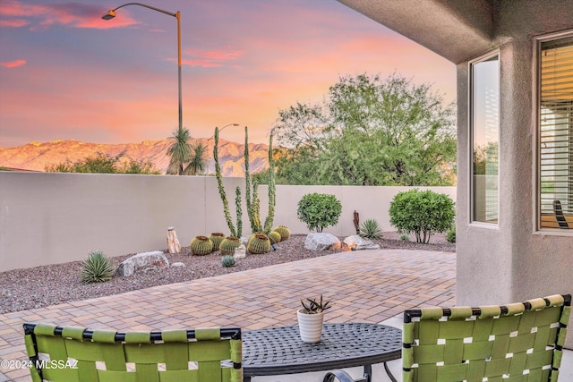 patio terrace at dusk featuring a mountain view