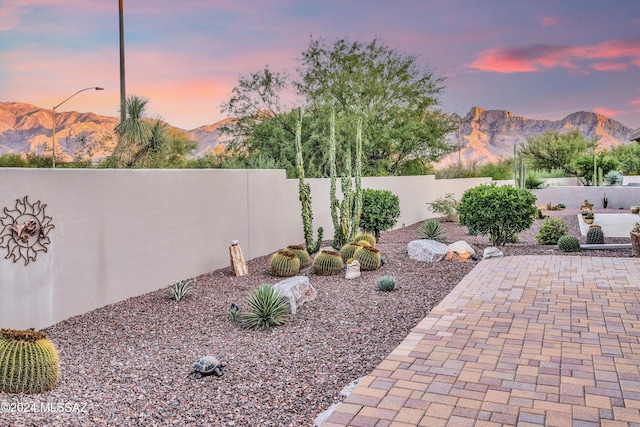 patio terrace at dusk featuring a mountain view