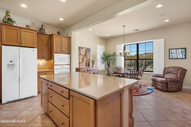 kitchen with light tile patterned flooring, decorative light fixtures, a notable chandelier, white appliances, and a center island