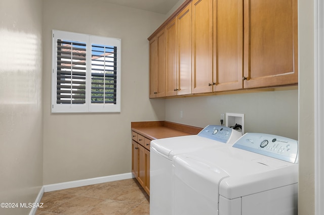 laundry area with cabinets, washer and clothes dryer, and light tile patterned floors