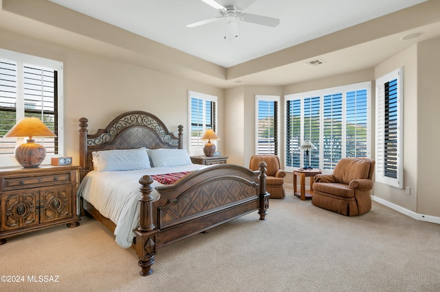 carpeted bedroom featuring multiple windows and ceiling fan