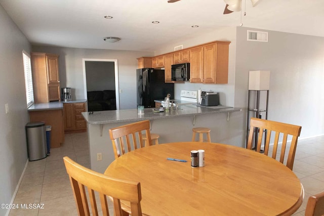 tiled dining space featuring ceiling fan