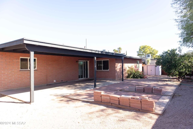 rear view of house with a patio and a storage unit