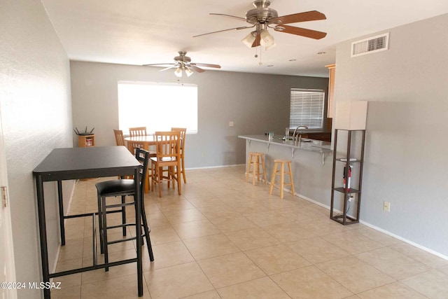 tiled dining area with sink and ceiling fan