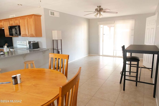 tiled dining area featuring ceiling fan