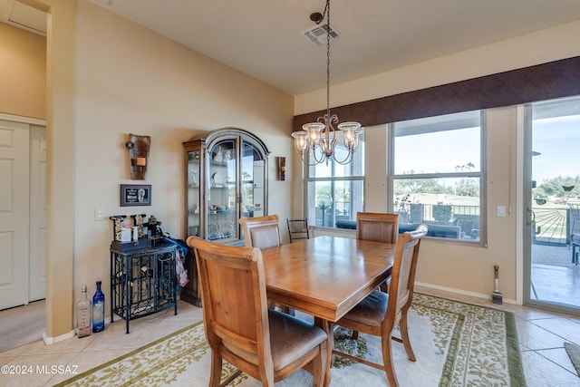 tiled dining area featuring a chandelier