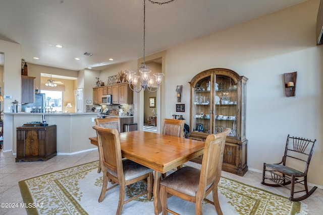 tiled dining area featuring ceiling fan with notable chandelier