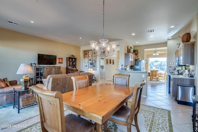 tiled dining space with ceiling fan with notable chandelier