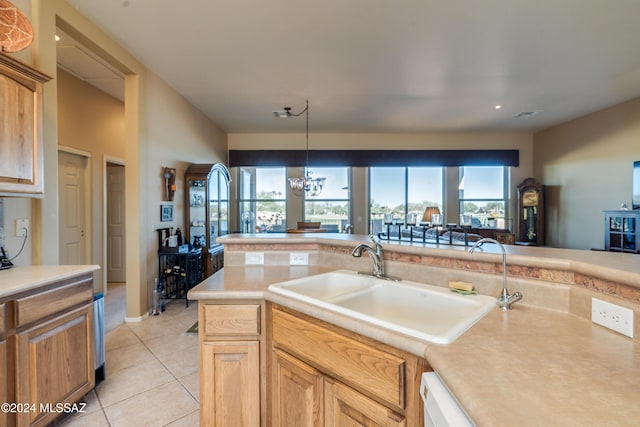 kitchen featuring light tile patterned floors, an inviting chandelier, hanging light fixtures, and sink