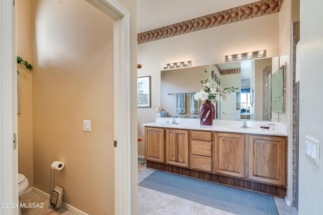 bathroom featuring tile patterned flooring, vanity, and toilet