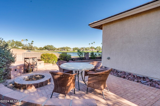 view of patio / terrace with a fire pit and a water view