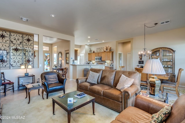 living room with light tile patterned floors and an inviting chandelier