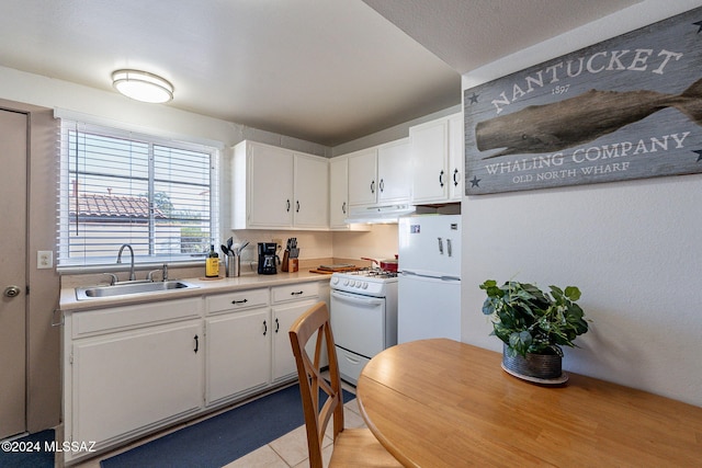 kitchen featuring sink, custom range hood, light tile patterned floors, white appliances, and white cabinets