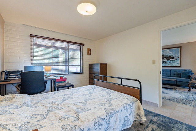 tiled bedroom featuring brick wall