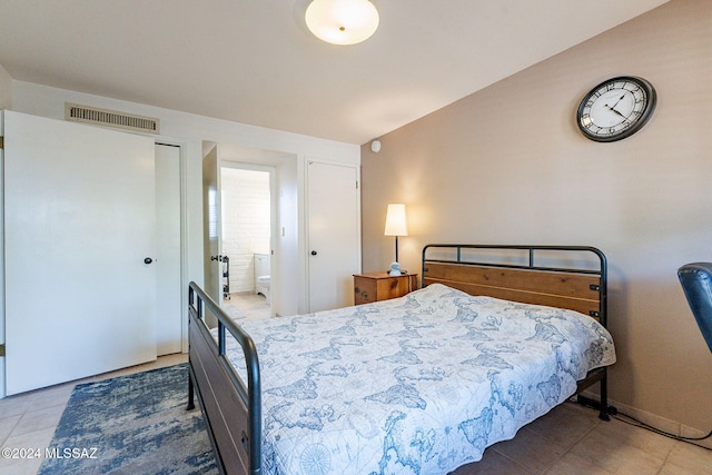 bedroom featuring tile patterned floors and connected bathroom