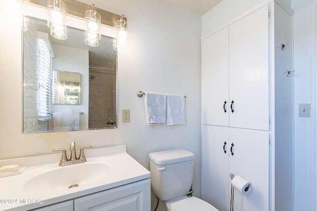 bathroom featuring vanity, toilet, and tiled shower