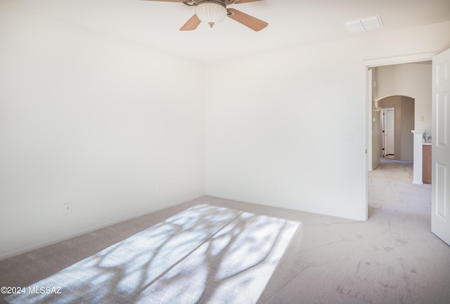 5567 W Dove Loft Dr, Marana, AZ 85658 - unfurnished room with arched walkways, light carpet, ceiling fan, and baseboards