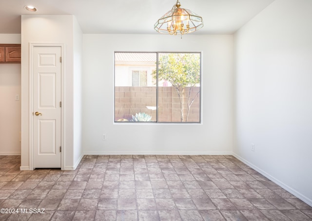 5567 W Dove Loft Dr, Marana, AZ 85658 - empty room with light stone finish flooring, baseboards, recessed lighting, and a chandelier