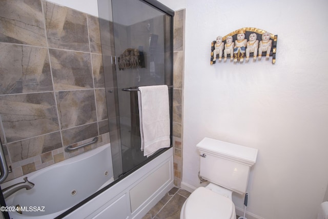 bathroom featuring tile patterned flooring, toilet, and bath / shower combo with glass door