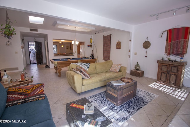 living room featuring a raised ceiling, light tile patterned floors, and pool table