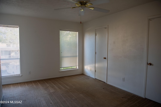 unfurnished bedroom with carpet flooring, multiple windows, and ceiling fan