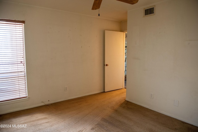 unfurnished room with light carpet and ceiling fan