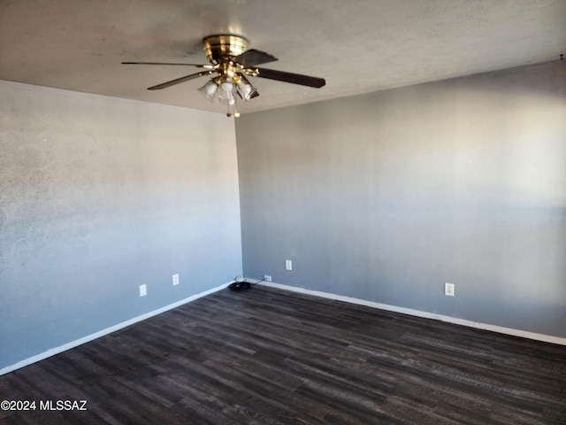 empty room with ceiling fan and dark wood-type flooring