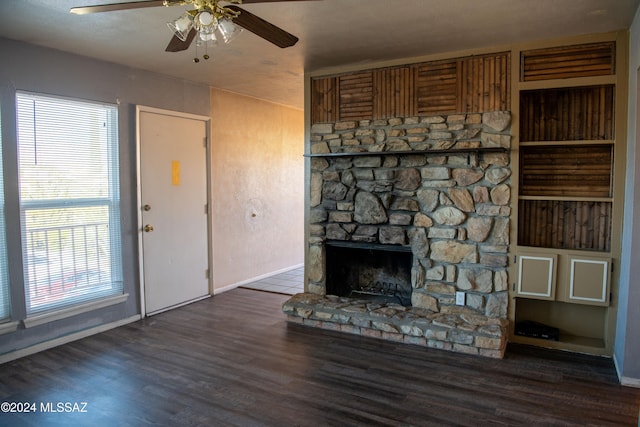 unfurnished living room featuring a fireplace, a textured ceiling, ceiling fan, and dark wood-type flooring