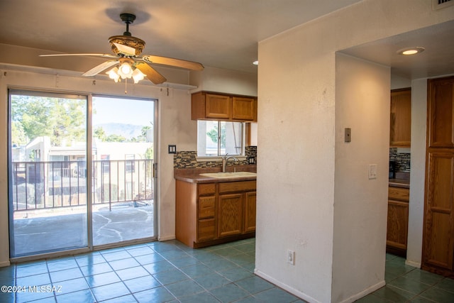 kitchen featuring a wealth of natural light, decorative backsplash, and sink