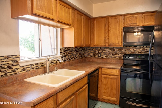 kitchen with decorative backsplash, sink, light tile patterned floors, and black appliances