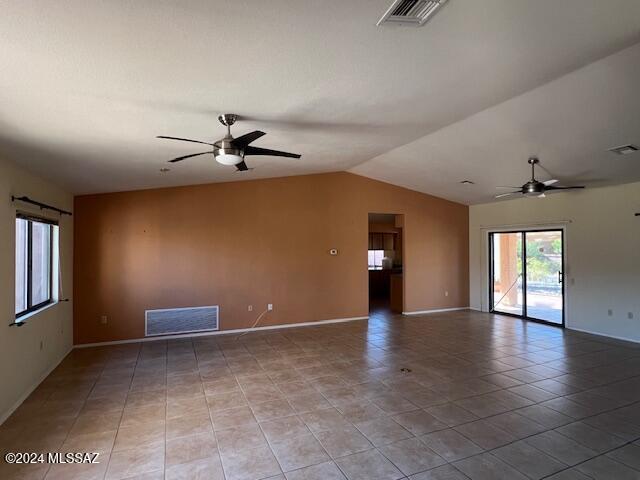 tiled empty room featuring ceiling fan and vaulted ceiling