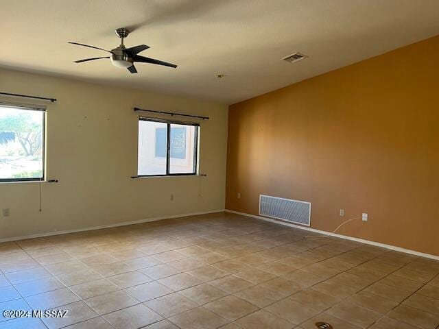 tiled spare room with ceiling fan and a wealth of natural light