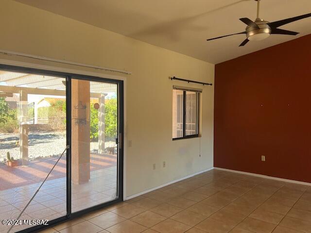 tiled empty room featuring ceiling fan