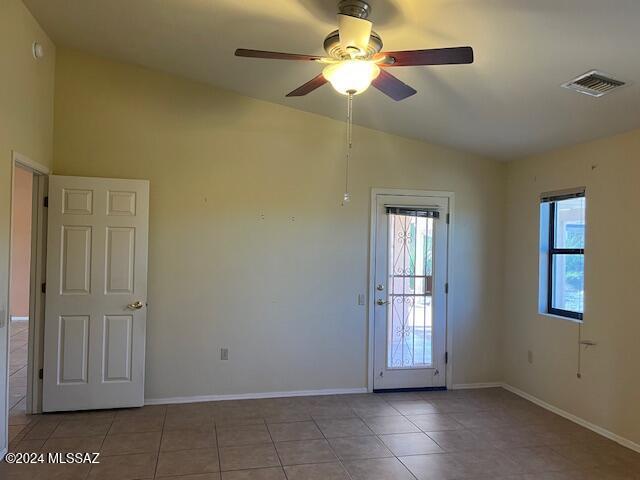 tiled spare room with lofted ceiling and ceiling fan