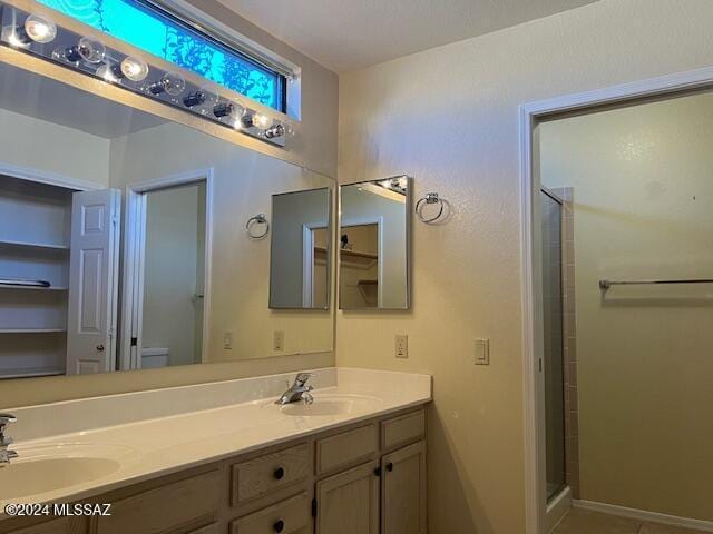 bathroom with tile patterned floors, walk in shower, toilet, and vanity