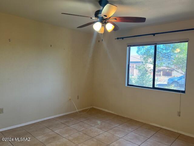 tiled empty room with ceiling fan