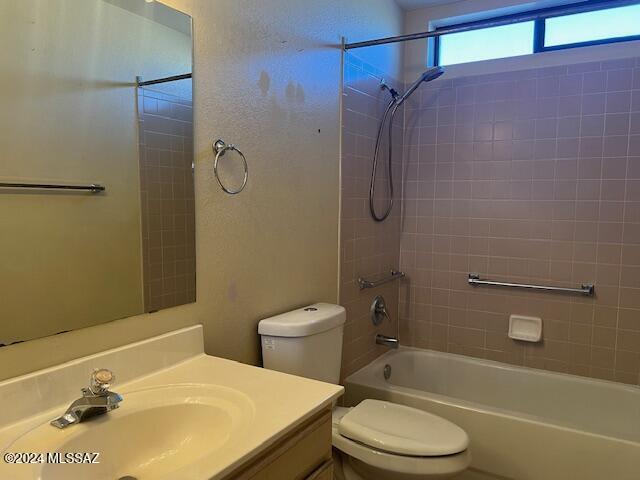 full bathroom featuring toilet, tiled shower / bath combo, and vanity