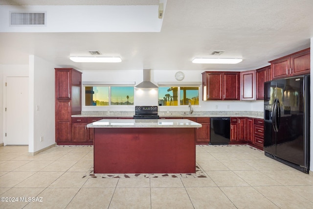 kitchen featuring wall chimney exhaust hood, black appliances, sink, a kitchen island, and light stone countertops