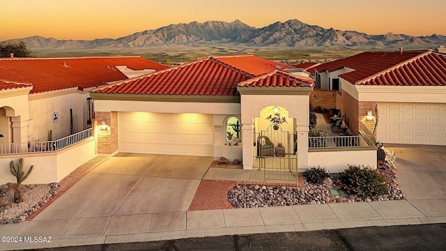 4115 S Constancia Ct, Green Valley, AZ 85622 - mediterranean / spanish house featuring concrete driveway, a tiled roof, a mountain view, stucco siding, and an attached garage