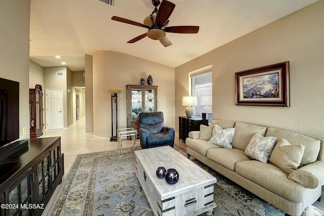 tiled living room featuring ceiling fan and vaulted ceiling