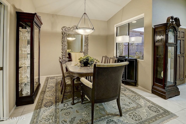 dining area featuring light tile patterned floors and vaulted ceiling